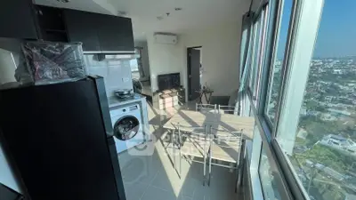 Modern kitchen with washing machine and stunning city view from high-rise apartment.