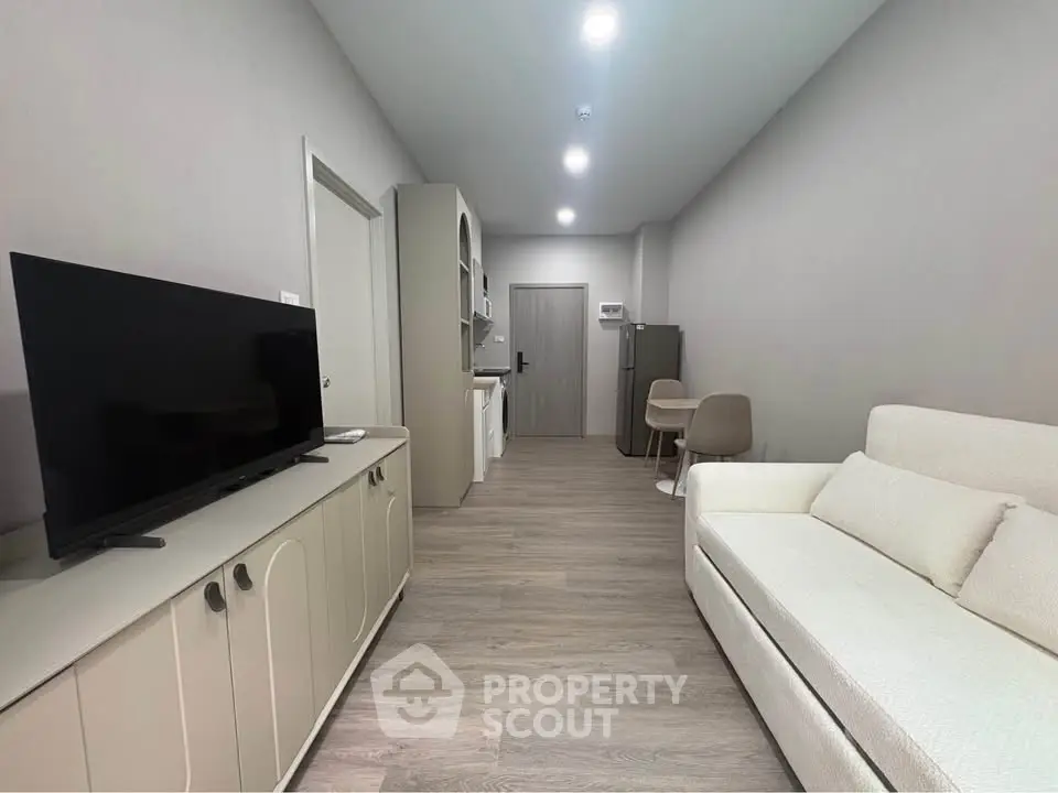 Modern living room with sleek furniture and open kitchen layout, perfect for urban living.