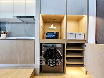 Modern kitchen with built-in washing machine and microwave in sleek cabinetry.