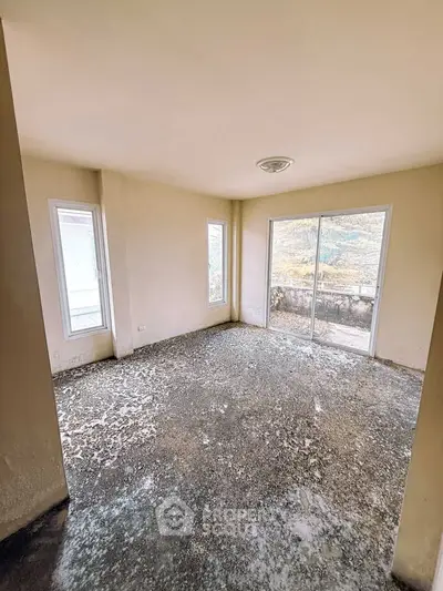 Spacious room with large windows and sliding glass door offering natural light and scenic views.