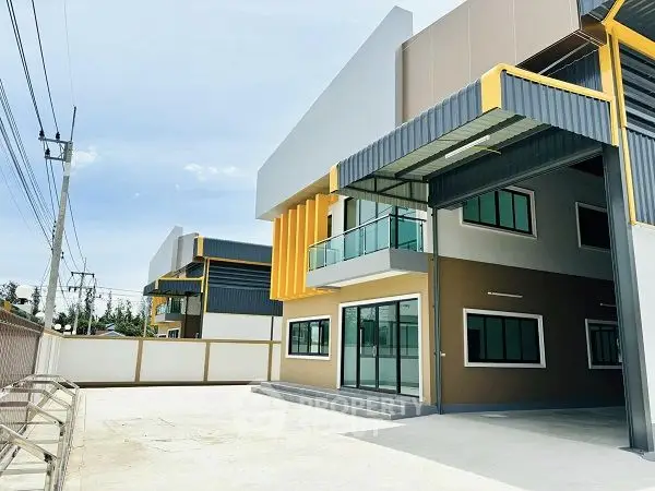 Modern industrial building with sleek design and spacious outdoor area.