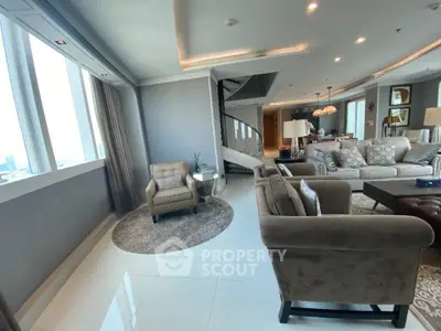 Luxurious living room with elegant decor and city view, featuring plush seating and modern lighting.