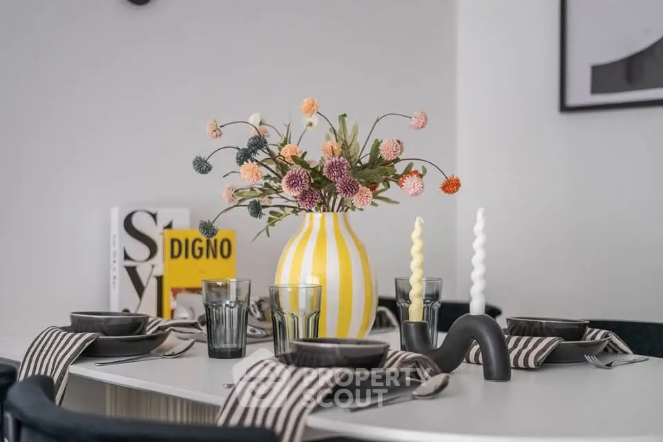 Stylish dining table setup with striped vase and modern decor in a contemporary home.