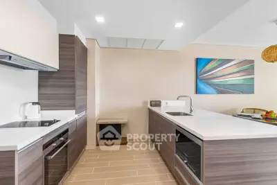 Modern kitchen with sleek cabinetry and island, featuring built-in appliances and stylish decor.