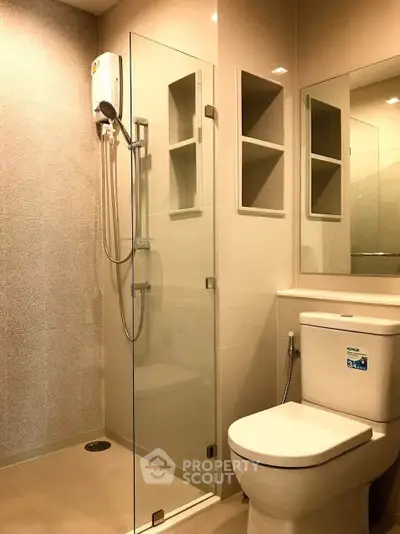 Modern bathroom with glass shower and sleek fixtures in a contemporary apartment.