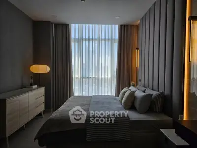 Luxurious bedroom with modern decor and floor-to-ceiling windows offering stunning views.