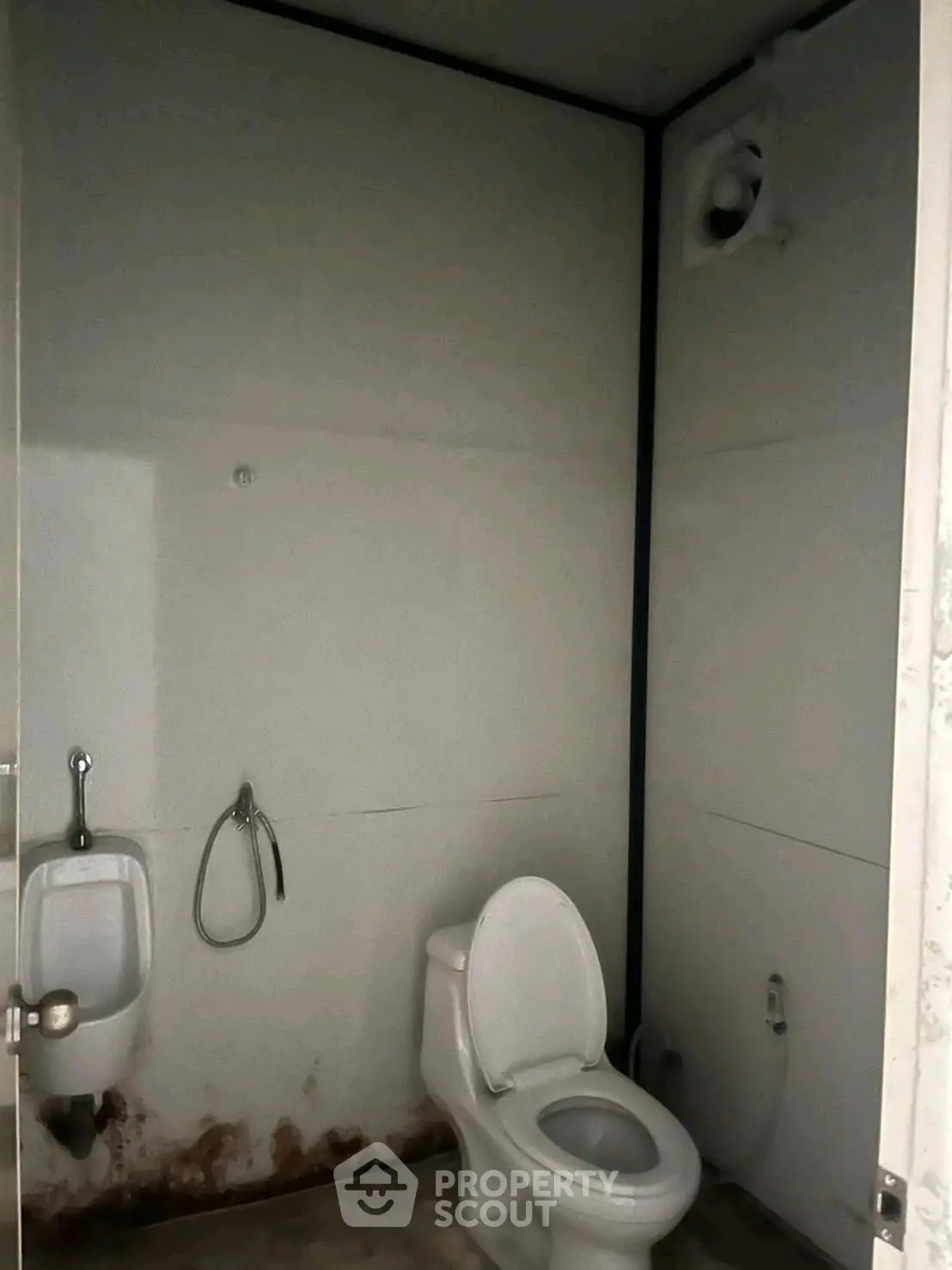 Basic bathroom with toilet and urinal in a minimalistic design.