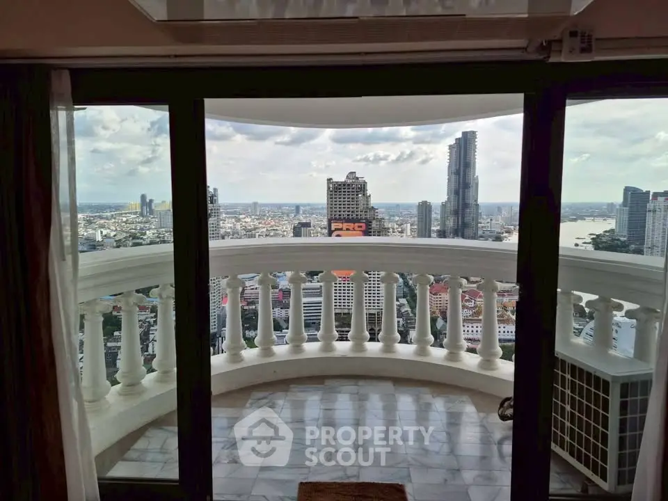 Stunning cityscape view from high-rise balcony with elegant railing and glass doors.