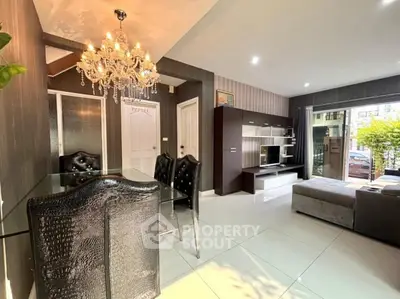 Elegant living room with chandelier and modern furniture, open layout design, abundant natural light.