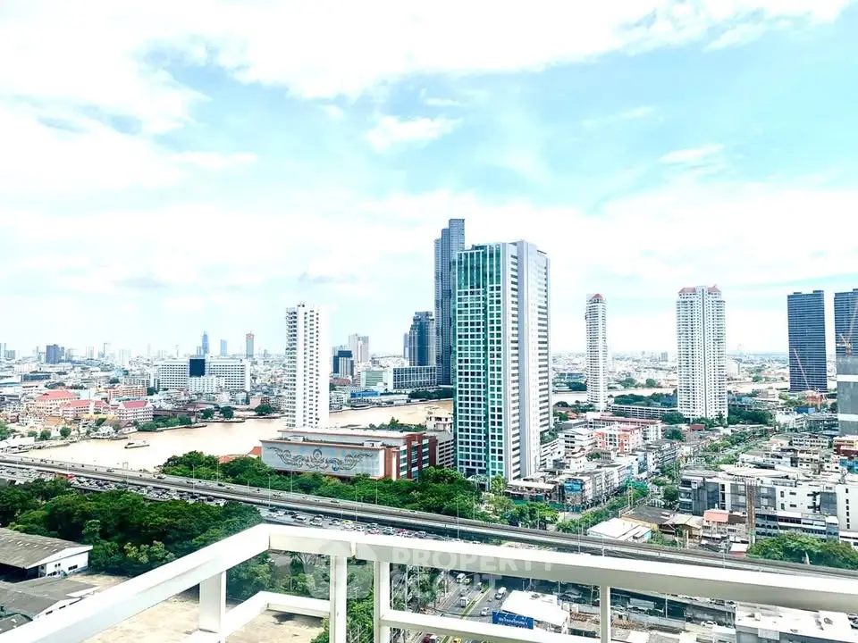 Stunning cityscape view from a high-rise balcony overlooking urban skyline and river.