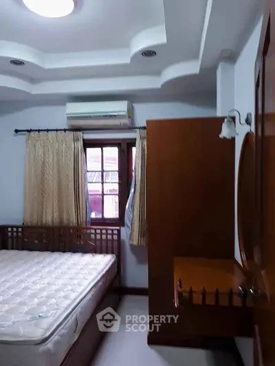 Cozy bedroom with wooden furniture and air conditioning