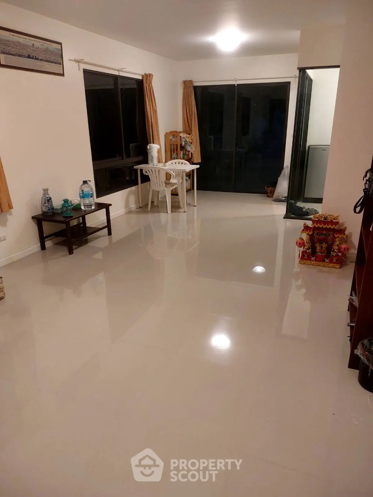 Spacious living room with glossy tiled floors and large windows