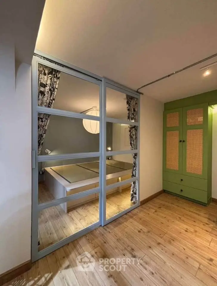 Chic bedroom with glass partition and stylish wardrobe in modern apartment