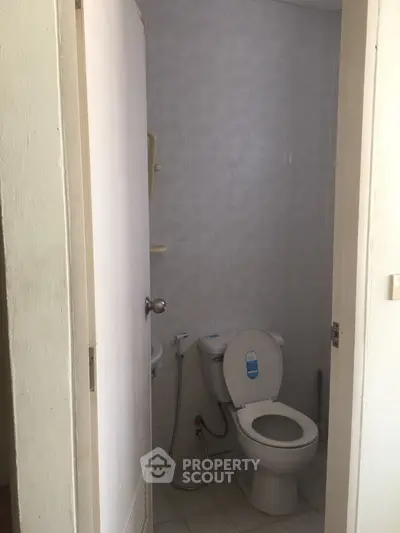 Compact bathroom with toilet and tiled walls, ideal for small spaces.