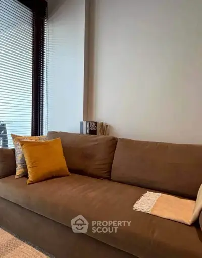 Stylish living room with cozy brown sofa and decorative pillows, perfect for relaxation.