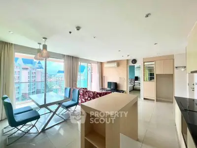 Spacious modern living room with open kitchen and large windows offering city views.