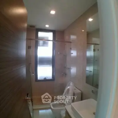 Modern bathroom with sleek fixtures and frosted window for privacy.