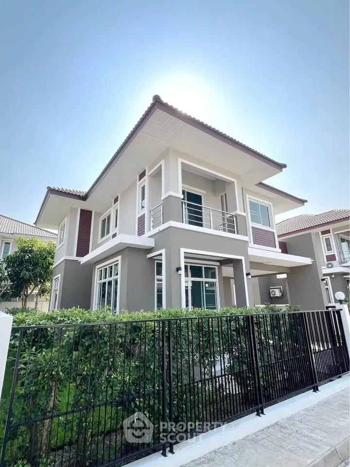 Modern two-story house with sleek design and lush greenery, perfect for family living.
