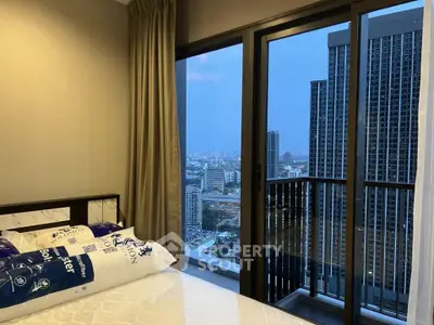 Modern bedroom with city view from high-rise balcony, featuring large windows and elegant decor.