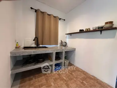 Cozy minimalist kitchen with open shelving and concrete countertops, perfect for modern living.