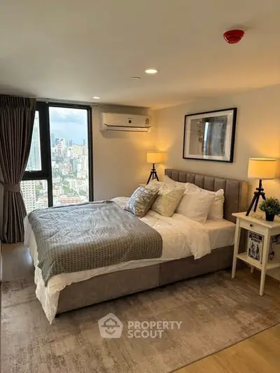 Luxurious bedroom with city view, modern decor, and cozy ambiance in high-rise apartment.