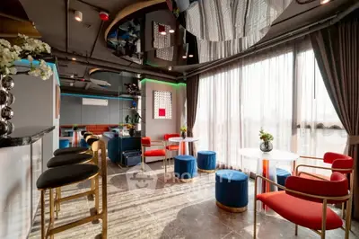 Stylish modern living room with vibrant decor and large windows offering natural light.
