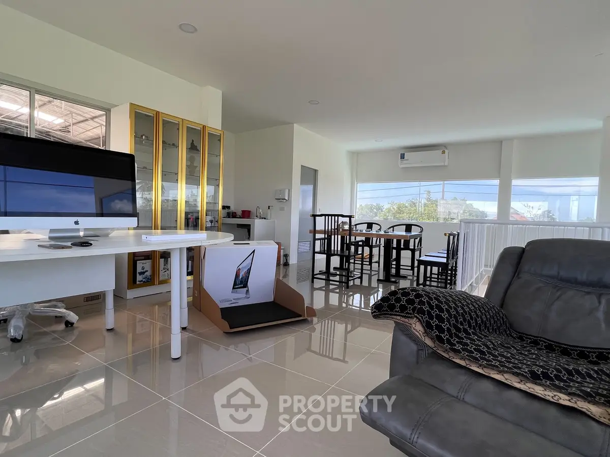Spacious modern living room with sleek furniture and large windows offering natural light and scenic views.