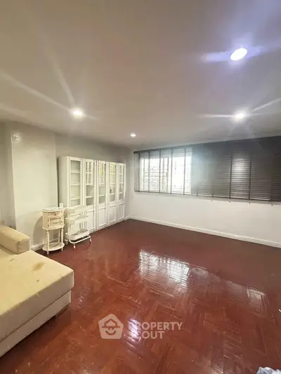 Spacious living room with wooden flooring and ample natural light
