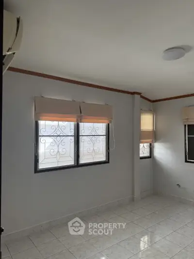 Spacious empty room with tiled floor and large windows, perfect for customization.