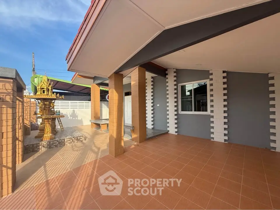 Spacious modern home exterior with tiled patio and unique architectural features.