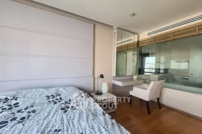 Spacious bedroom with modern decor and large window offering natural light.