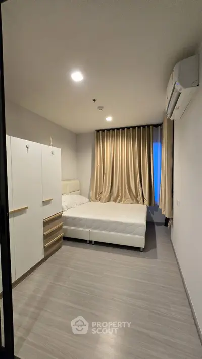 Modern bedroom with sleek design and air conditioning in a stylish apartment.