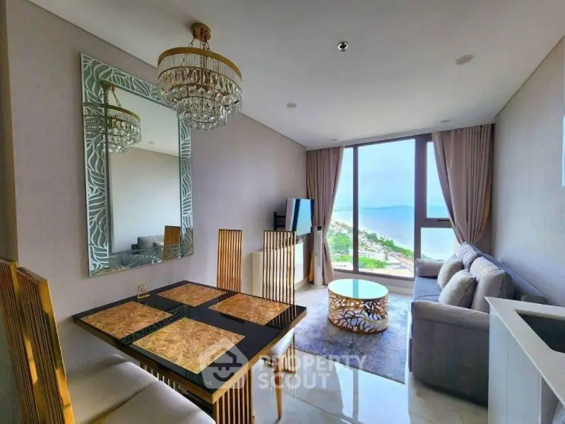 Luxurious living room with ocean view, elegant chandelier, and modern furniture.
