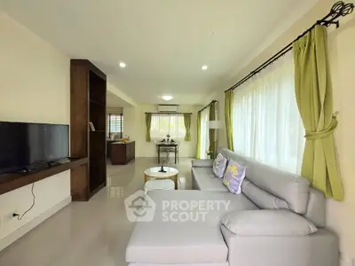 Spacious living room with modern decor and large windows for natural light