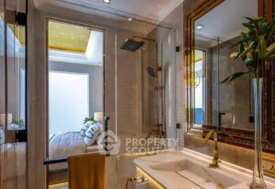 Luxurious bathroom with glass shower and elegant decor in modern apartment.