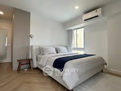 Modern bedroom with stylish decor and natural light, featuring a cozy bed and sleek flooring.