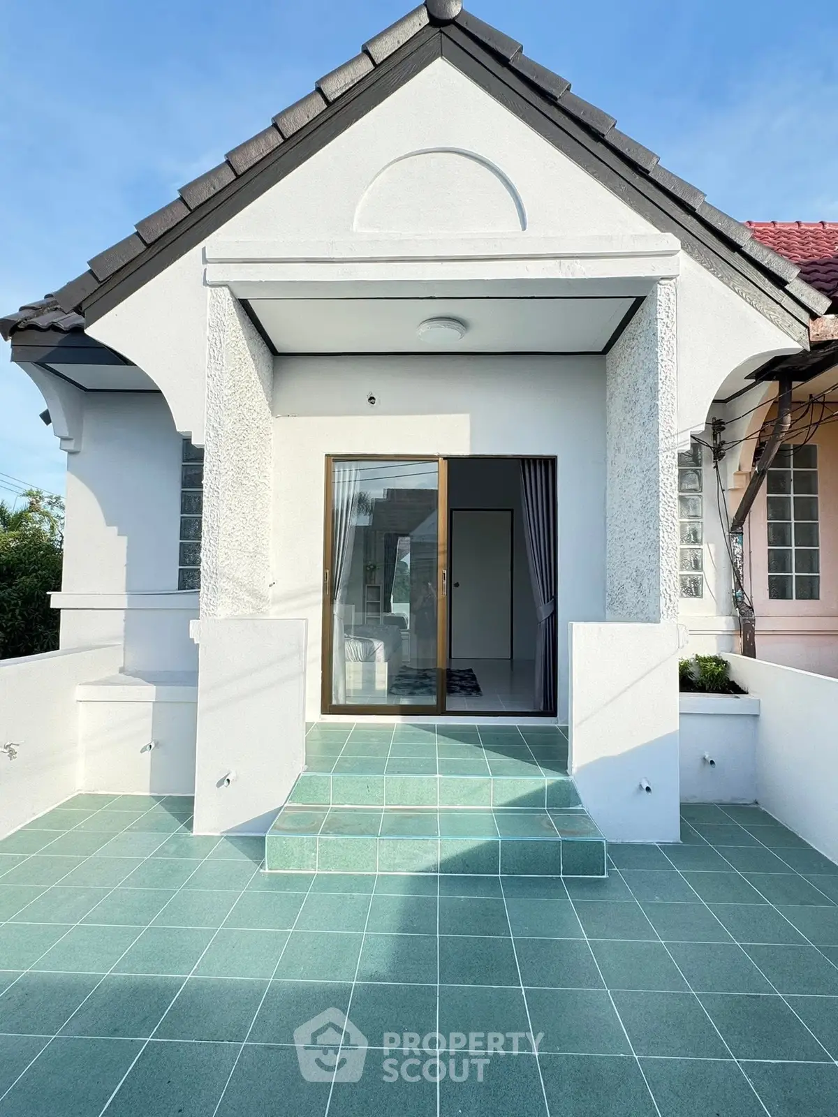 Charming single-story home with modern facade and spacious tiled entrance.