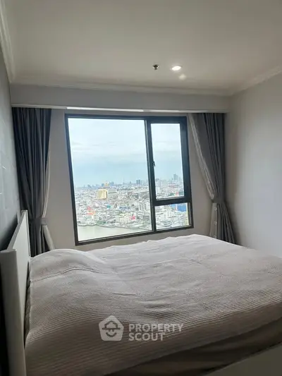 Spacious bedroom with stunning city view from large window, perfect for urban living.