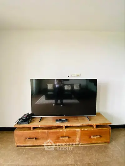 Modern living room with sleek TV on wooden stand and minimalistic decor