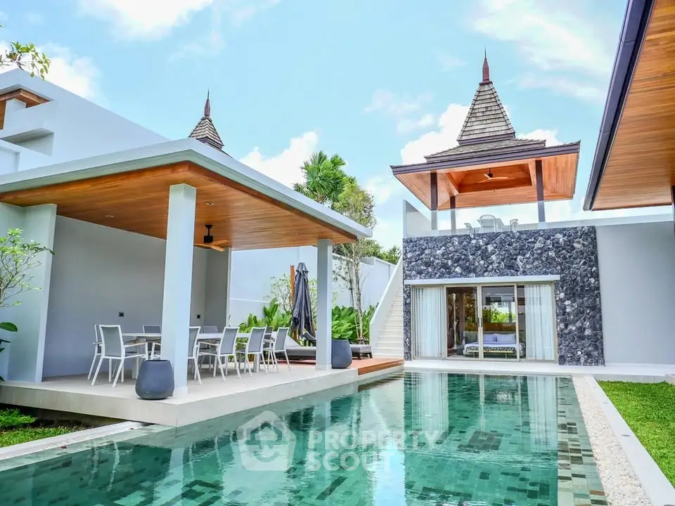 Luxurious tropical villa with private pool and modern outdoor dining area.
