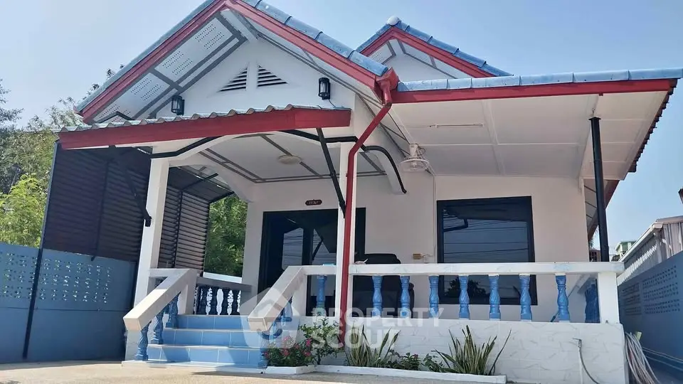 Charming single-story house with blue accents and inviting front porch.