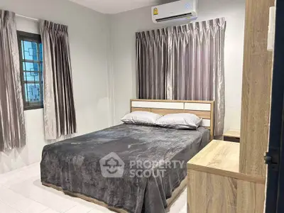 Cozy bedroom with modern furnishings and air conditioning, perfect for comfort and relaxation.