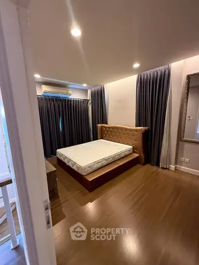 Spacious bedroom with elegant decor and large windows for natural light