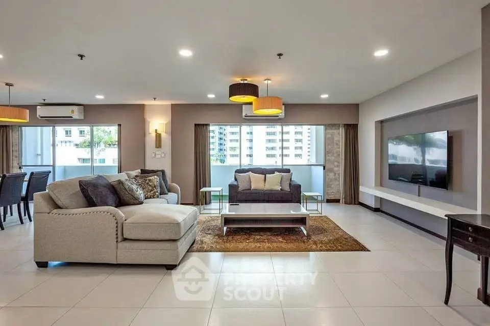 Spacious modern living room with elegant decor and large windows offering natural light.