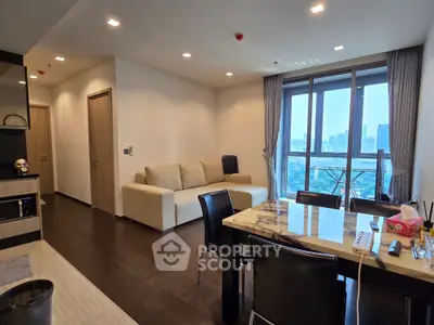 Modern living room with city view, elegant dining area, and cozy seating in a high-rise apartment.