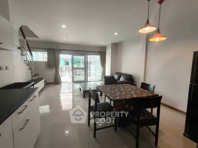 Spacious open-plan living and dining area with modern lighting and large windows.
