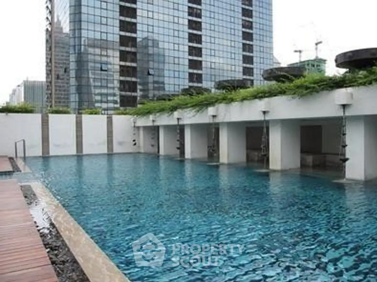 Luxurious rooftop pool with city skyline view in modern high-rise building.