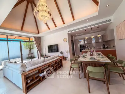 Luxurious open-plan living and dining area with vaulted ceiling and elegant chandelier.