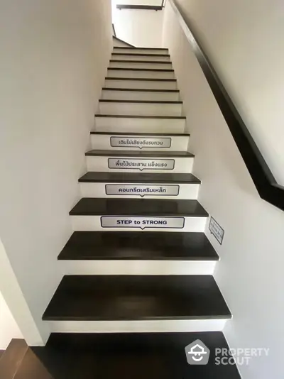 Modern staircase with motivational quotes on each step in a stylish home interior