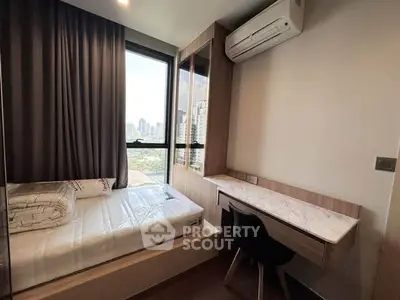 Modern bedroom with city view, featuring a sleek desk and air conditioning.